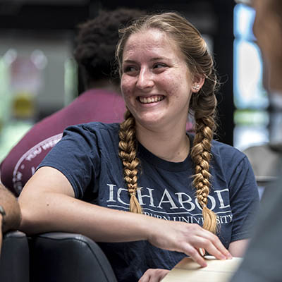 A student smiles while wearing a Washburn shirt.