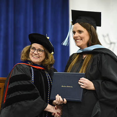 A student receives their diploma at graduation.