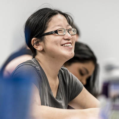 A student smiles while taking notes in class