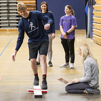 A group of kinesiology students observe a fitness test.