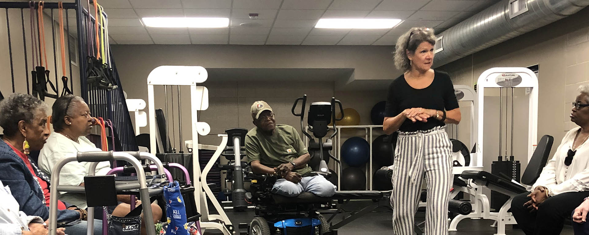 WU moves trainer speaking with community member clients in the gym.