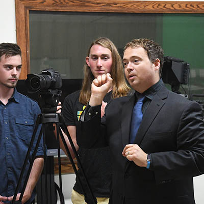 A film professor gestures while explaining a video concept.