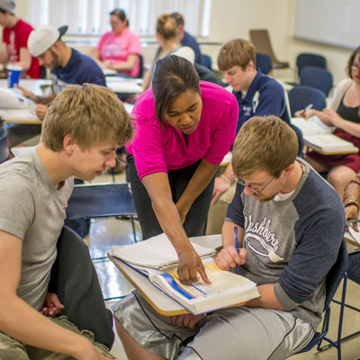 students working with the instructor in a Spanish class