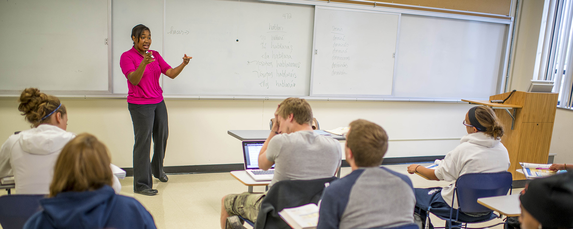 A professor of Spanish explains something in front of the class.