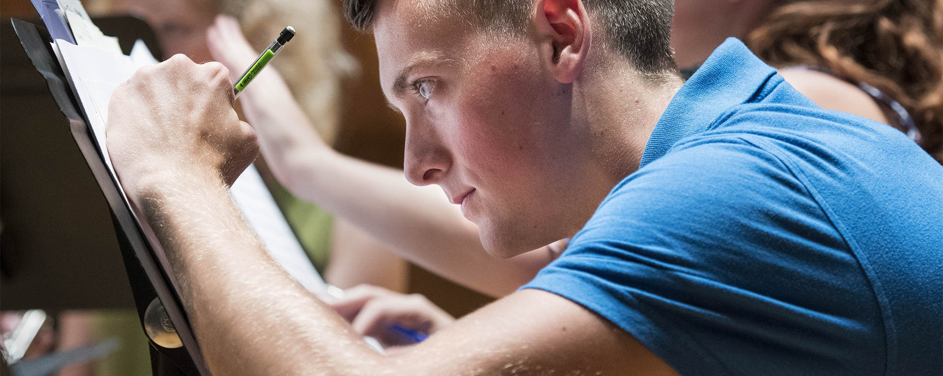 A student edits his music sheet during rehearsal