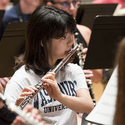 Student plays a woodwind during ensemble practice