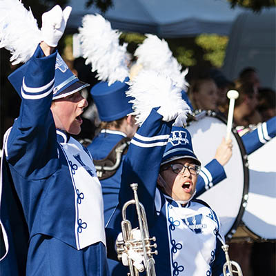 Marching band members cheer during a performance