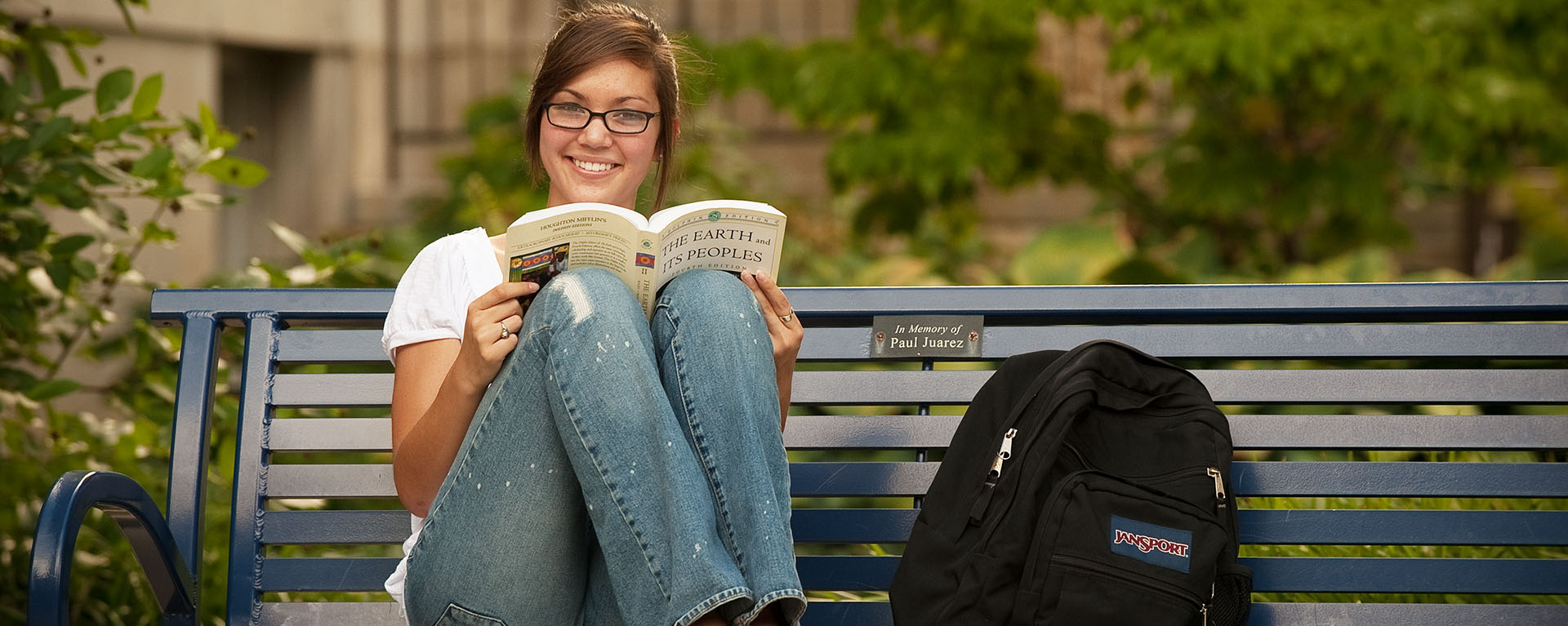 Young woman reading on bench