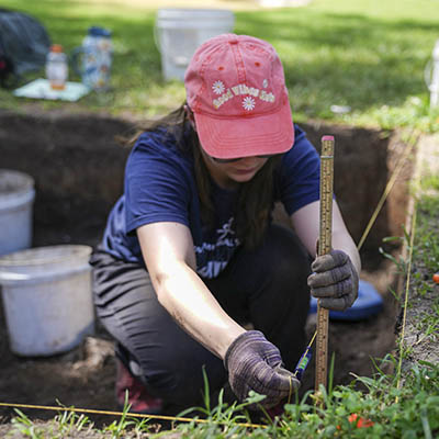 A student works at an archaeology site.
