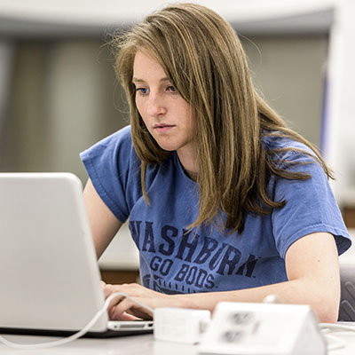 A Washburn student works on her laptop in the KBI Forensics Lab.