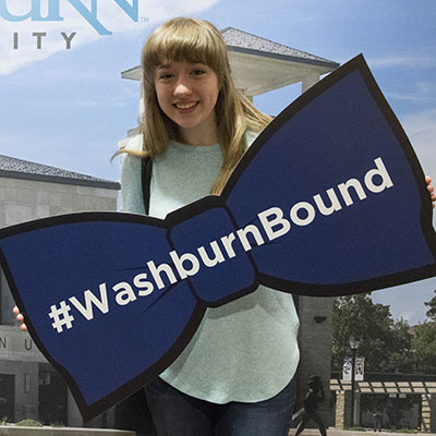 A future Ichabod holds the #WashburnBound bowtie during a scholarship dinner at Washburn.