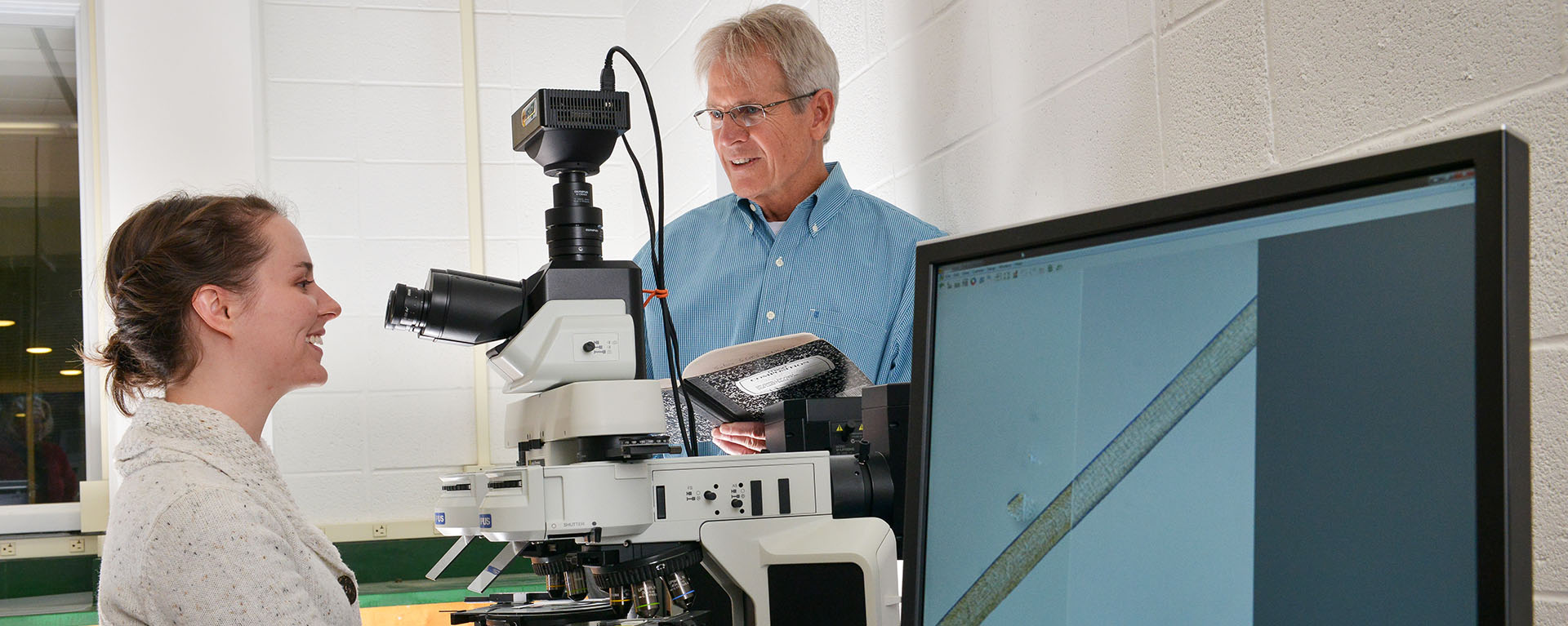 girl looking into microscope