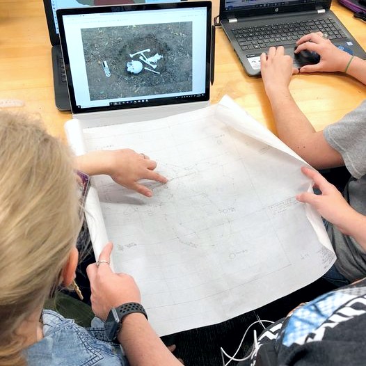 Forensic students exam a map of bones