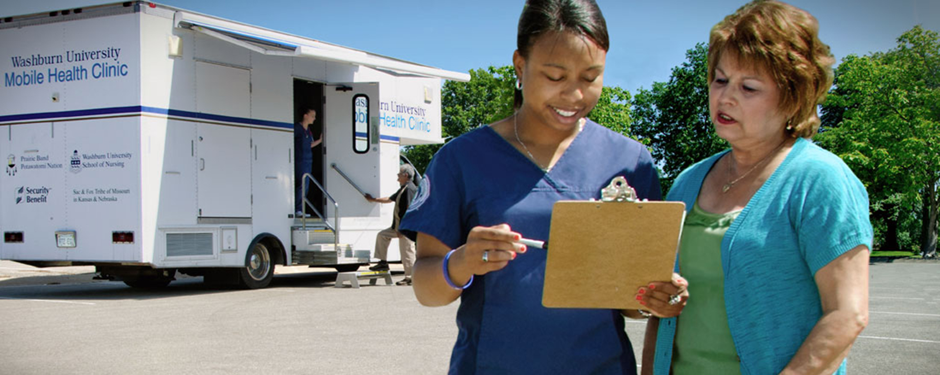 a nurse speaking with a woman in front of a mobile nursing vehicle