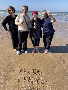 Petra with three other students studying abroad, standing on a beach
