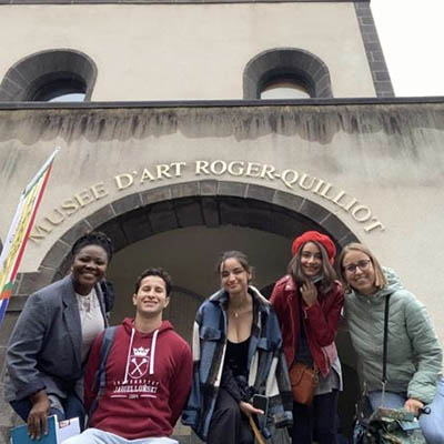 Group of students pose and smile at a museum at Mont-Ferrand