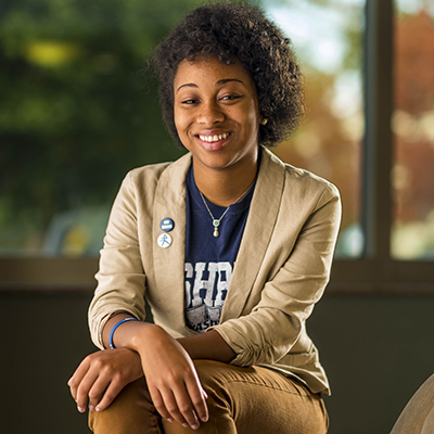 A student smiles while wearing a Washburn shirt and suit jacket.