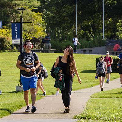 Students walking and smiling on campus 