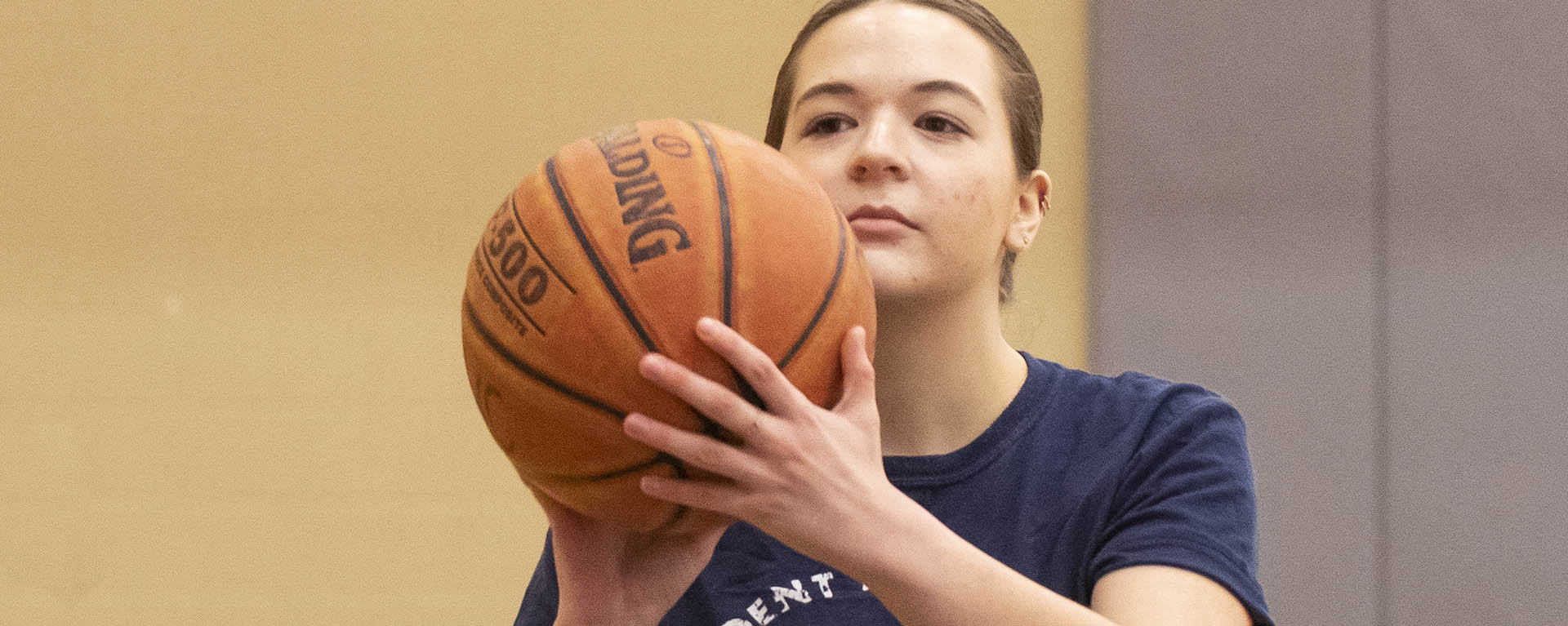 A student lines up a shot with her basketball.