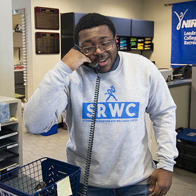 A student employee talks on the phone.