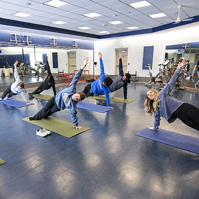 Students participating in a yoga group exercise class.