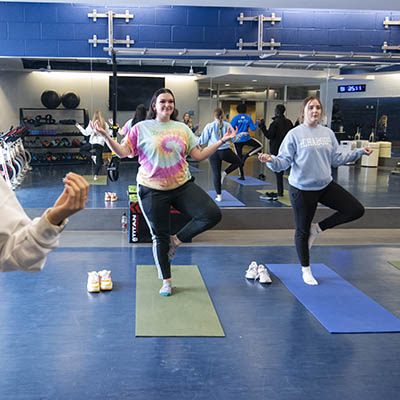 Students do yoga during a group exercise class.