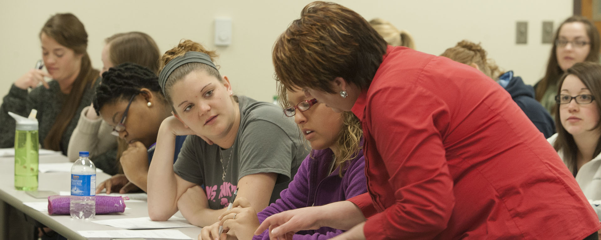 A Washburn professor works with a student during a School of Nursing class.