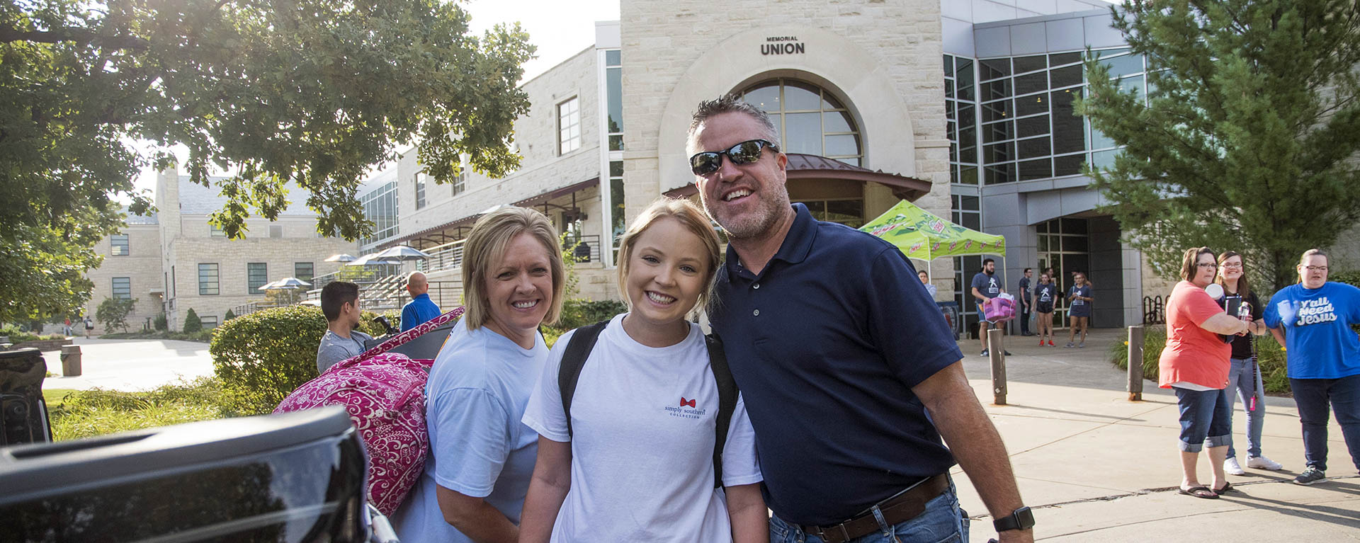 A family pose for a photo on move in day at Washburn University.