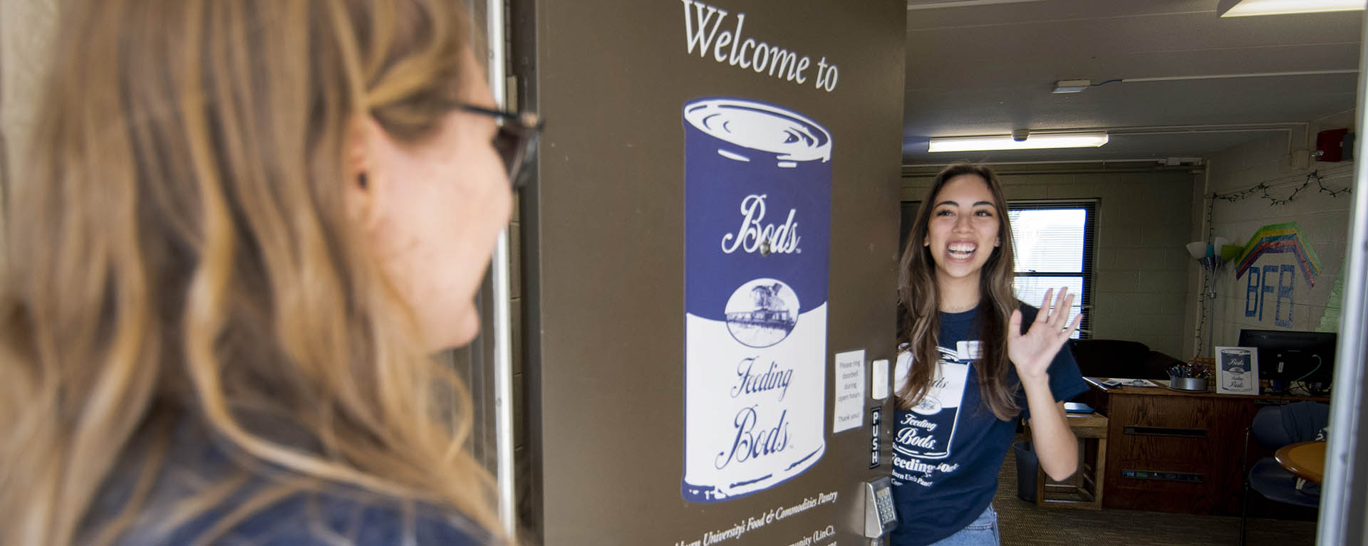 A student stocks the shelves of the Bods Feeding Bods food pantry.