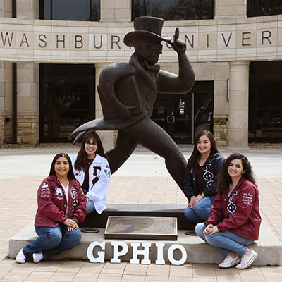 Members of a sorority pose with an Ichabod statue