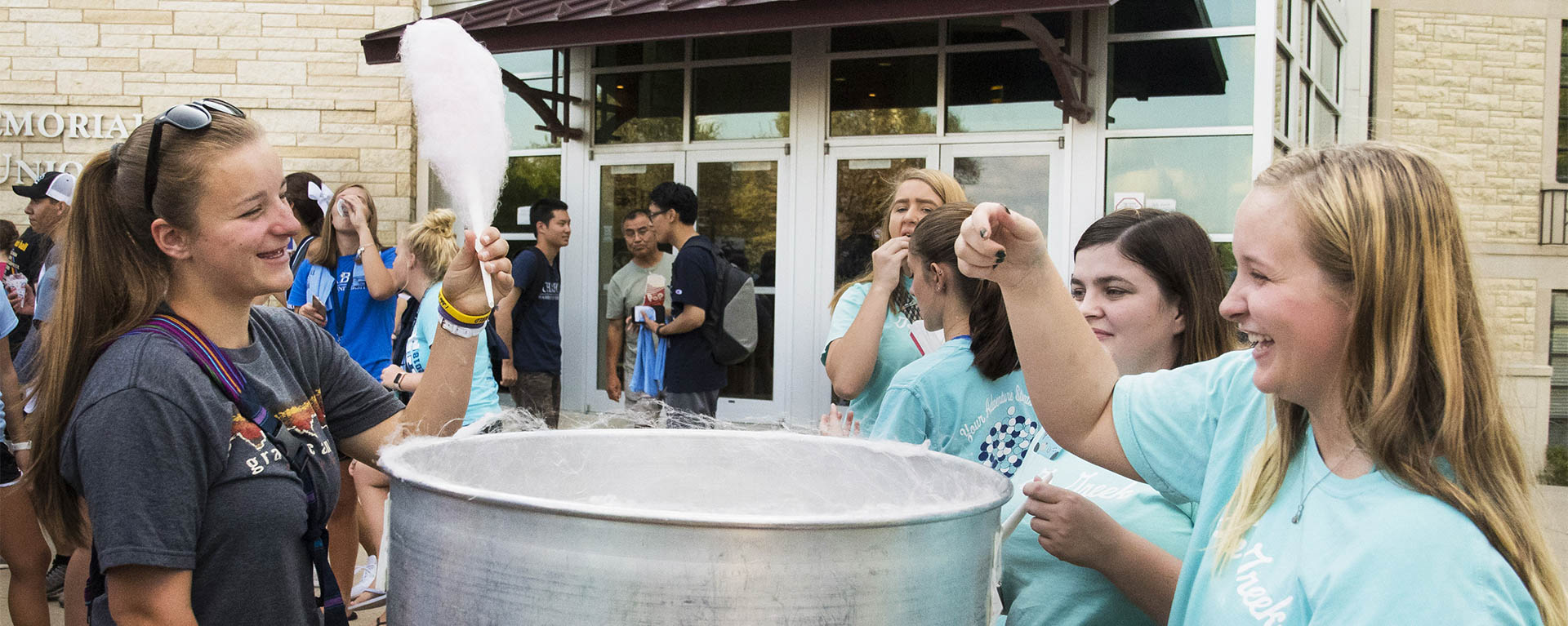 A sorority member hands out cotton candy at WU Fest