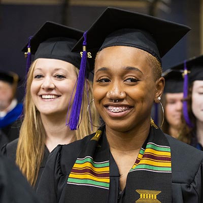 two students in regalia smiling