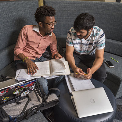 Students study with books spread out around them.