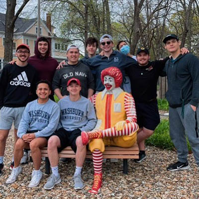 Big Event volunteers pose with a Ronald McDonald statue.