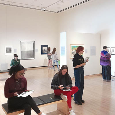 Students observing art in an art gallery.