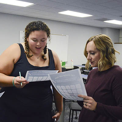 The leadership director and a student discuss a plan.