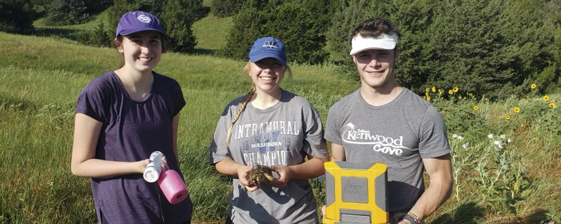 Research students smile while conducting turtle research.