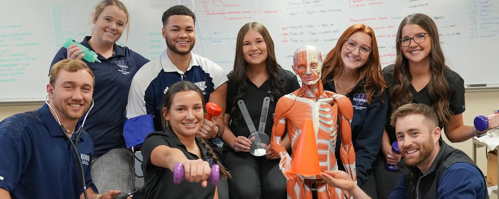 Students with health equipment pose for a photo.