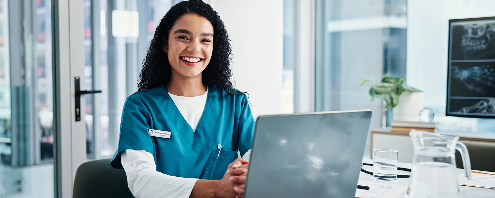 A health care education leader works online with a laptop.