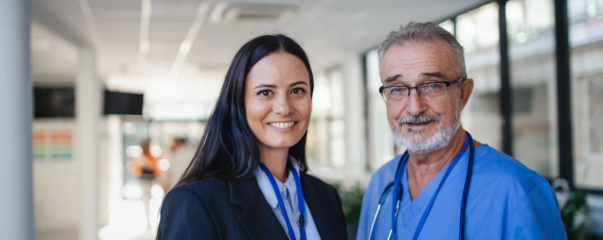 Two healthcare leaders smile in a clinical setting.