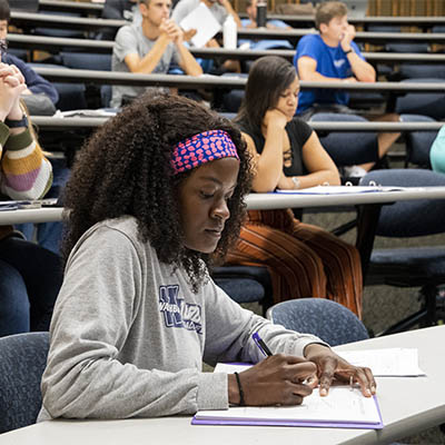 A student takes notes while in class.