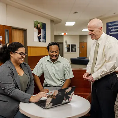 A professor works with two adult students.