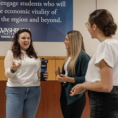 A group of business students talk in the hallway.