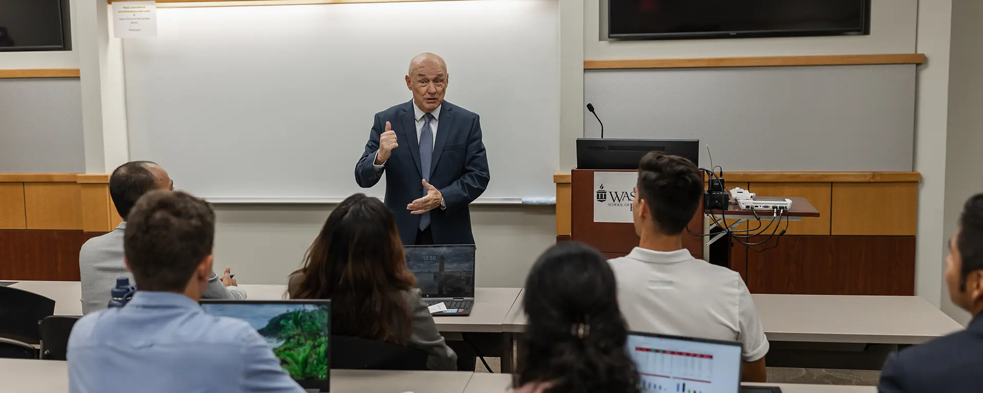 A business professor speaks before a class.