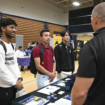 Students talk with employers at a career fair.