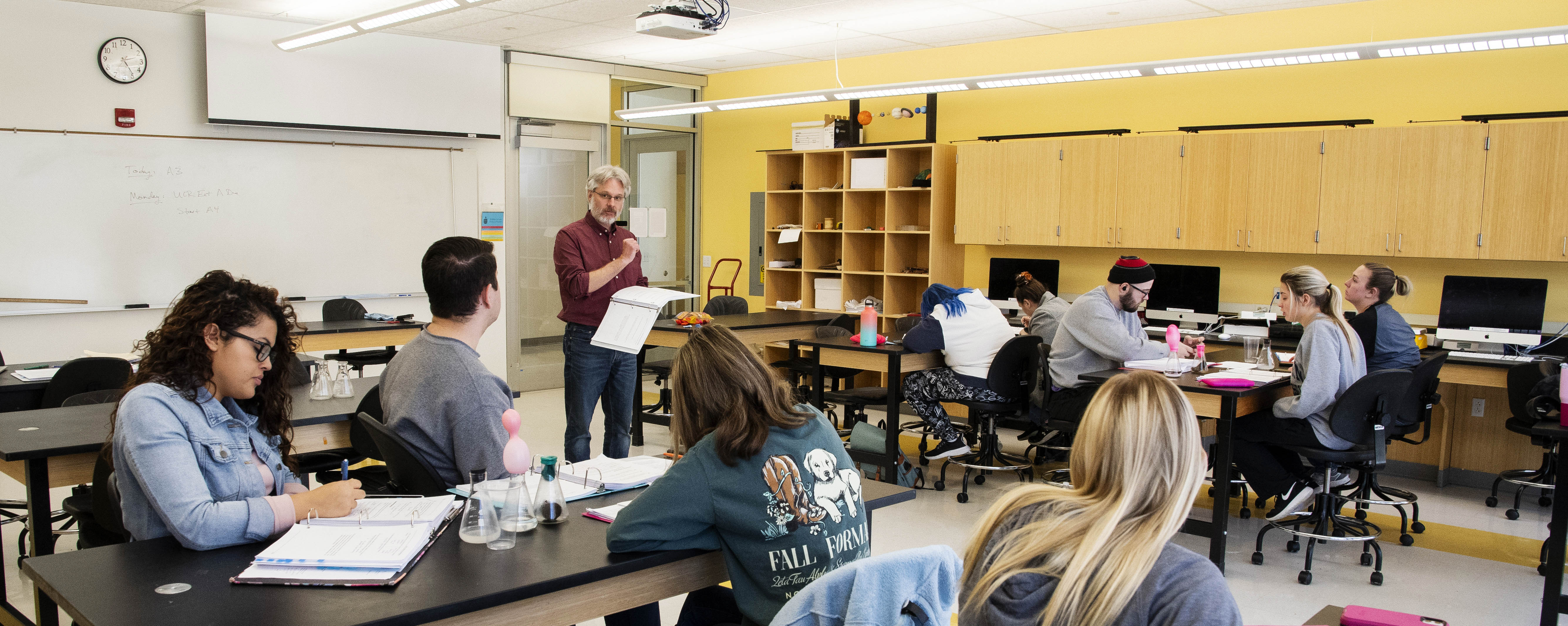 students and professor in physics lab