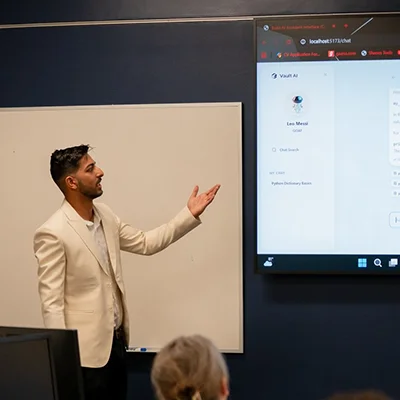 A student smiles while talking with a student over a laptop