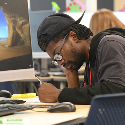 A student smiles while studying a paper