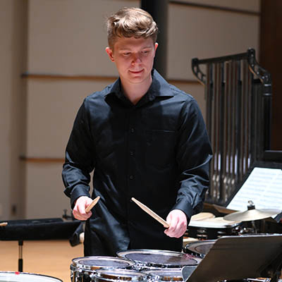 A student playing a drum.