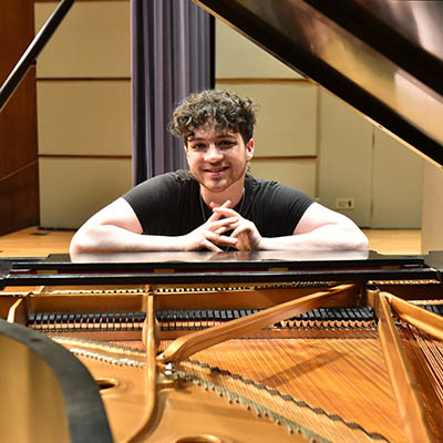 student at piano smiling